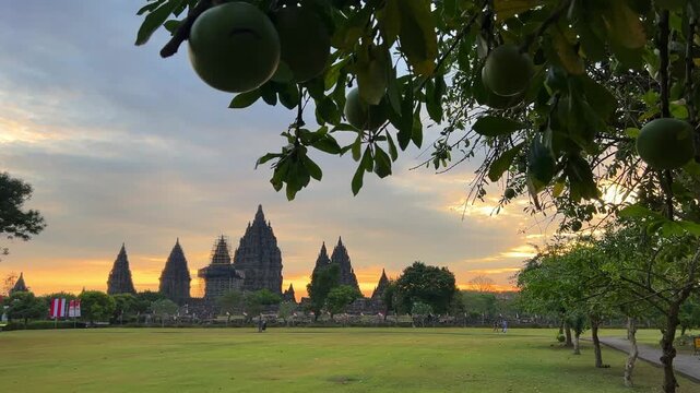View of the ancient Prambanan Temple at sunset, a Hindu temple complex in Yogyakarta,Indonesia. The temple rises above the green foliage under a multicolored sky, on the southern slope of Mount Merapi