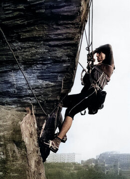 Khortitsa, Zaporozhye, USSR - May 15, 1984: A man climbs a rock wall in climbing gear. He is wearing sportswear and a helmet.