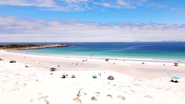 Drone view of beachgoers on scenic Moonlight Beach in Pringle Bay with clear sea
