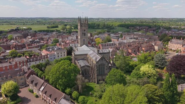 Orbiting footage of St Mary&rsquo;s Church in Warwick on a sunny day, with the surrounding village visible, highlighting historic architecture and a calm town atmosphere.