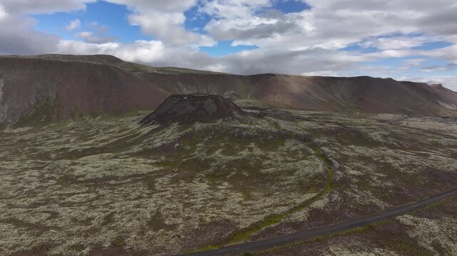 A drone circles and flies directly over the Eldborg Volcanic Crater in Iceland on a beautiful blue sky day in Fall in the land of fire and ice