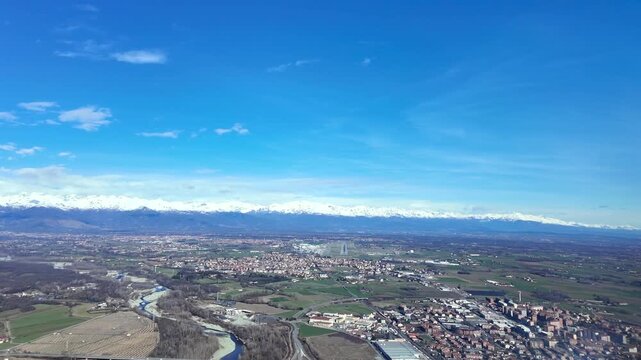 An immersive cockpit view in the final approach to Turin airport runway, with the Alps mountains peaks covered by snow in a bright winter morning.