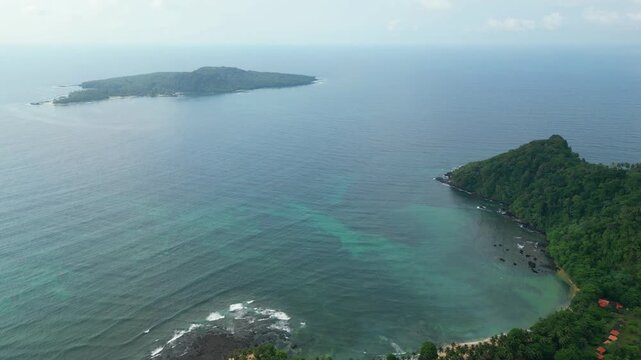 Flying backwards over the resort and beach Inhame with Ilh&eacute;u das Rolas in the background.An islet at S&atilde;o Tom&eacute; archipelago located in the Gulf of Guinea, south of the island. Africa