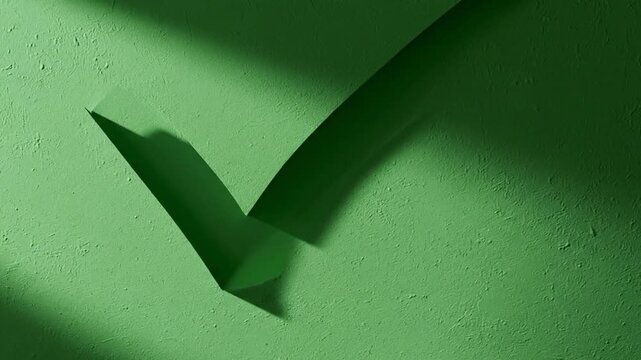 Checkmark on green surface with dramatic shadows from above viewpoint
