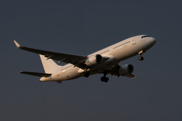 Obraz premium Passenger Airplane in Flight Against Dark Sky with Landing Gear Down during Dusk or Dawn for Travel Tourism and Aviation Industry Concepts