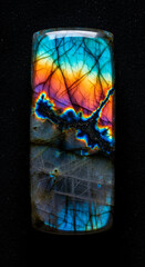 Fototapeta premium Close-up of rectangular labradorite with colorful iridescent effect on black, showcasing natural beauty and geological formation, ideal for gem concept