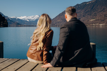 Fototapeta premium young couple sitting on a bench at sunset