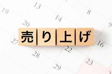 「売り上げ」と書かれたブロックとカレンダー