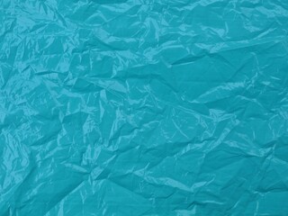 Fototapeta premium Crumpled teal blue plastic texture background. Perfect for creative backgrounds, waste management concepts, or industrial textures