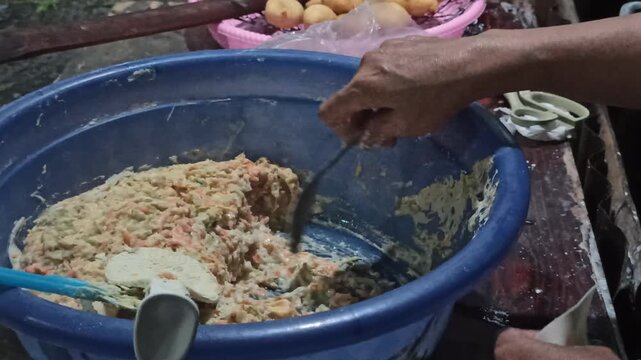 A close-up of siomay wrappers being carefully filled with seasoned dough, ensuring consistent portioning, balanced texture, and proper sealing before frying to achieve optimal structure and flavor.