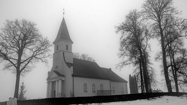 spring landscape with a small rural church in the morning mist, damp foggy and cloudy weather