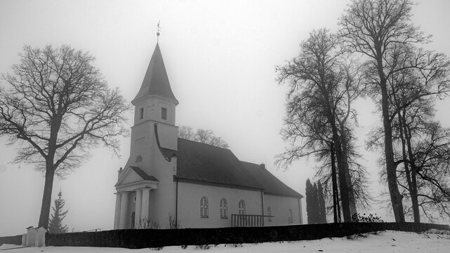 spring landscape with a small rural church in the morning mist, damp foggy and cloudy weather