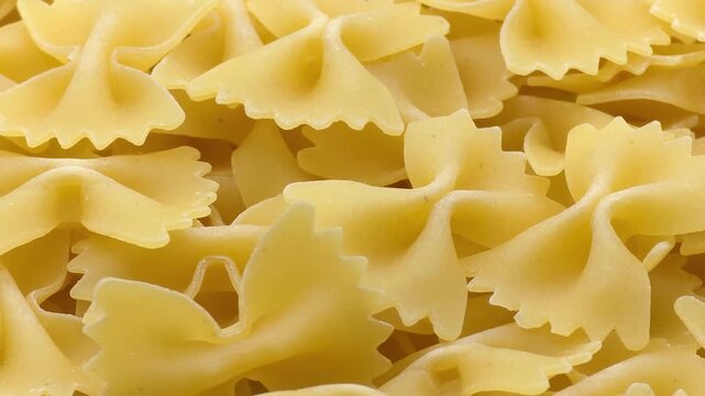 Uncooked Italian farfalle bow tie pasta background macro close up