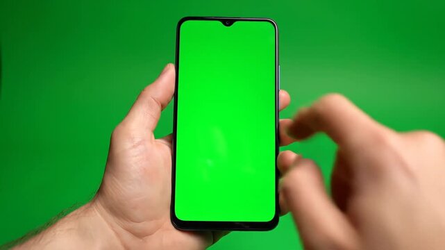 Hand Holding Smartphone With Bright Green Screen Background.