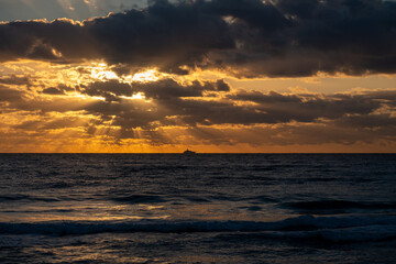Luxury Yacht Silhouette on Ocean Horizon at Dramatic Golden Sunrise with Sun Rays © Rob Kennedy