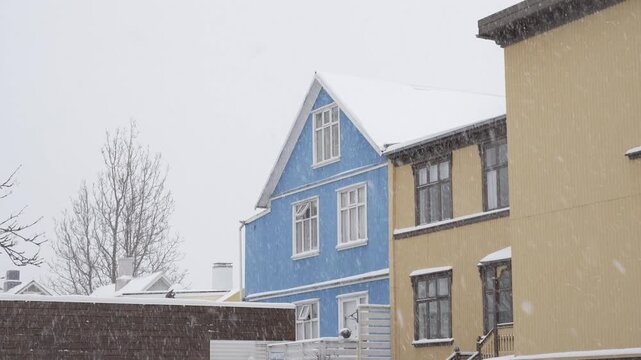 Traditional colorful houses in Reykjavik during a snowfall.