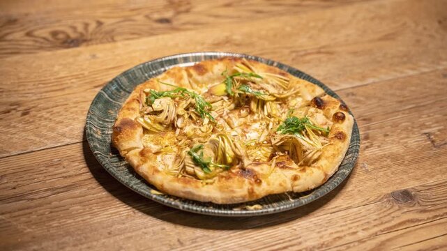 Progressive serving of Italian pizza with artichokes adding one slice at a time on plate