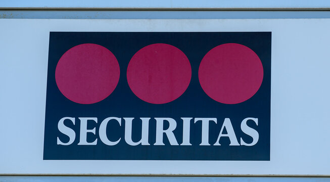 Falkenberg, Sweden, october 5, 2024: The iconic Securitas logo, featuring three red circles and bold text, stands out against a clear blue sky, showcasing security services