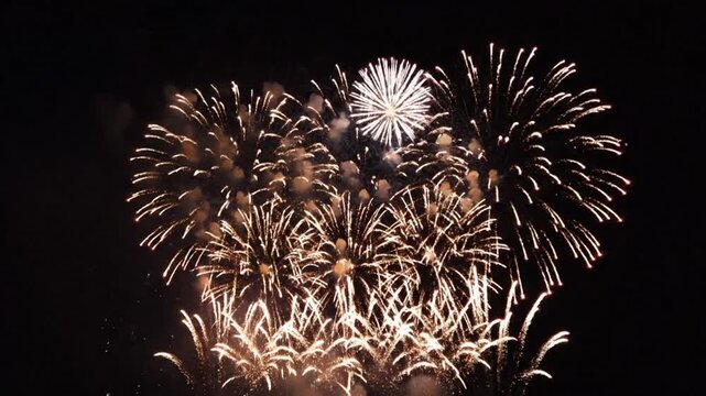 Vibrant red and white fireworks explode in a dark night sky, creating a festive holiday atmosphere with trails of smoke.