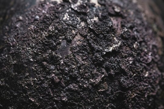 Extreme macro photography of deeply tarnished and black oxidized silver metal surface