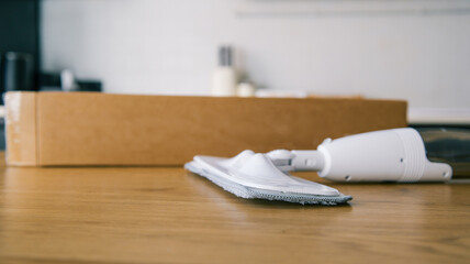 New spray mop with microfiber pad and cardboard box on a wooden table © shine.graphics