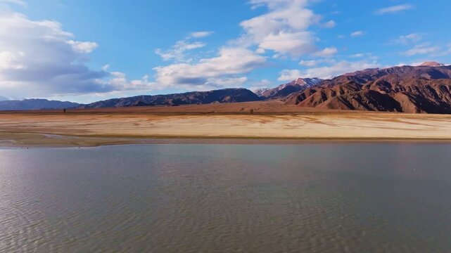Drone view Orto Tokoy reservoir in Kyrgyzstan at sunny autumn day. Dolly forward camera movement.