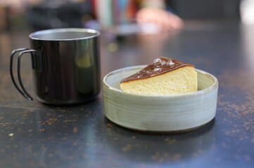 Pieces of cheesecake with Black coffee in a Stainless Steel Cup.
