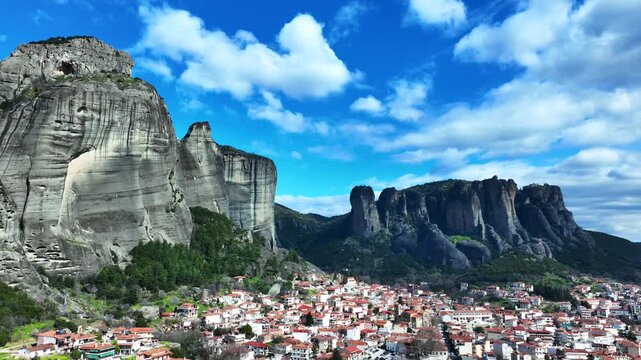 Aerial drone cinematic video of breathtaking view of famous rock pillars of Meteora featuring Orthodox monasteries as seen from village of Kalabaka, Thessaly, Greece