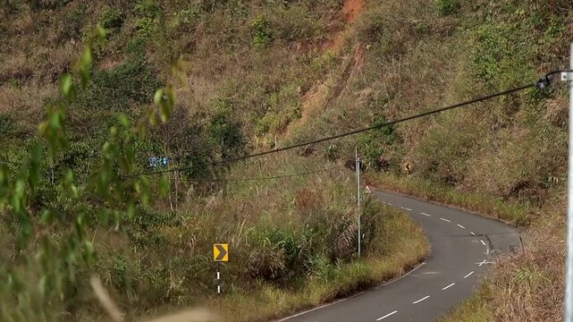 Sharp Curving Hill Road With Warning Signs in Countryside