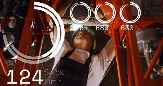 Mechanic lying under vehicle reaching upward as HUD readouts rising, guiding tightening of fittings