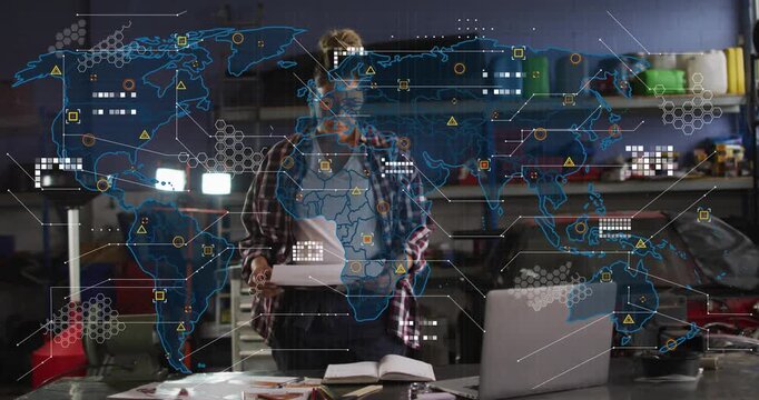 Woman sorting papers in garage, glancing down and checking laptop as tech data map overlay growing