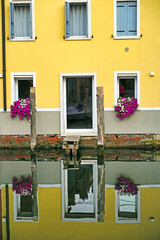 Fototapeta premium Old yellow house reflected in water, Chioggia, Italy
