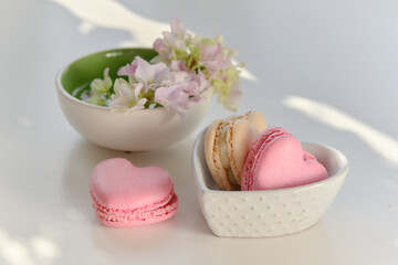 Hydrangea arrangement with heart macarons in ceramic bowls and soft copy space