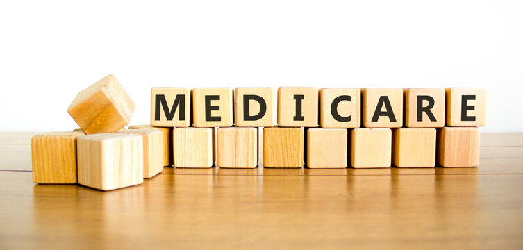 Medicare word symbol. Concept word Medicare on beautiful wooden blocks. Beautiful wooden table white background. Medical support help medicare word concept. Copy space.