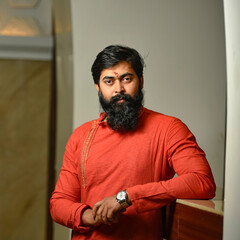 Obraz premium Confident bearded man with bold attitude and charming personality expressing power, style, and masculinity with an Indian traditional look in traditional wear in a striking portrait