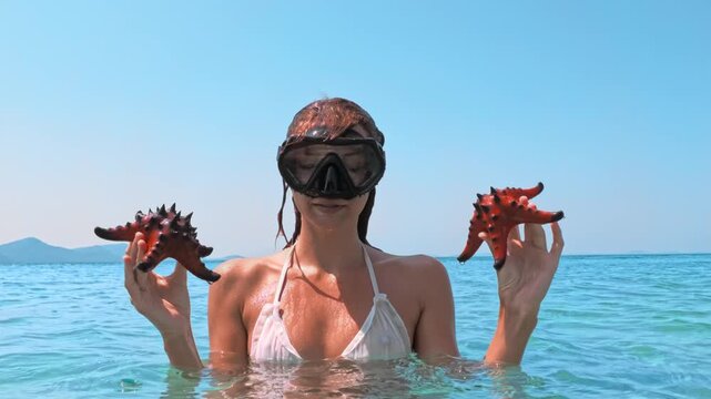 Snorkeling Woman Showing Starfish in Clear Shallow Water in Vietnam