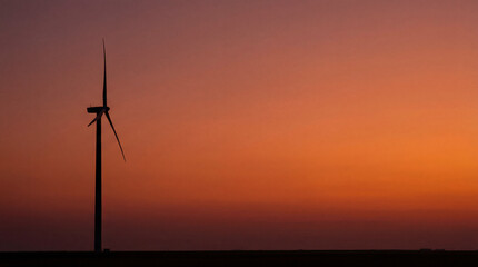 Obraz premium Wind turbine silhouette at fiery sunset. Wind turbine stands on horizon for earth day campaign, clean power concept, turbine energy transition message with dramatic sky and wide copy space
