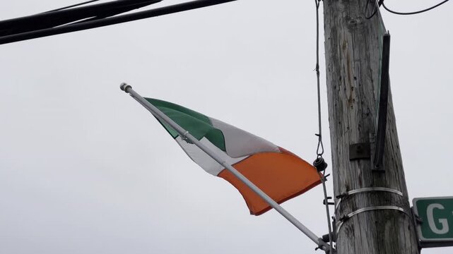 Irish flag for the St Patrick's day parade on a telephone pole blowing in the wind Irish flag for the St Patrick's day parade on a telephone pole blowing in the wind 