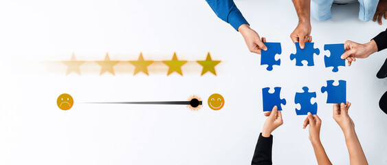 Diverse hands collaborate to assemble blue puzzle pieces while engaging with rating icons,...