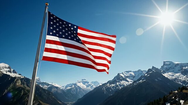 American Flag with Mountain Backdrop - This video shows the national flag of the United States of America waving on a pole, set against a stunning background of mountains, a clear blue sky, and the