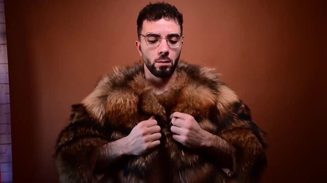 Confident young man wearing a luxurious raccoon fur coat
