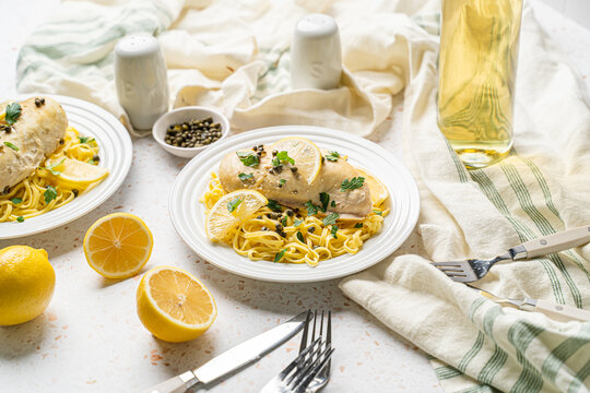 Healthy chicken piccata with lemon and capers over pasta