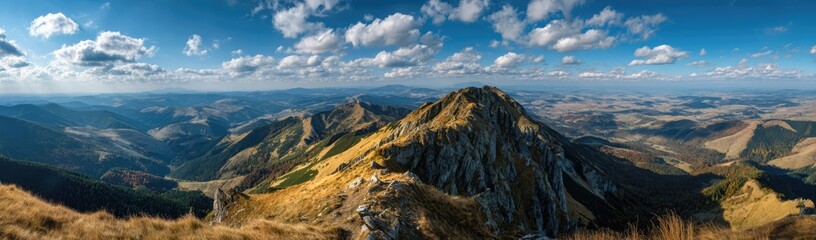 Fototapeta premium Panoramic View of Majestic Mountain Landscape Under a Vibrant Blue Sky with Fluffy Clouds.
