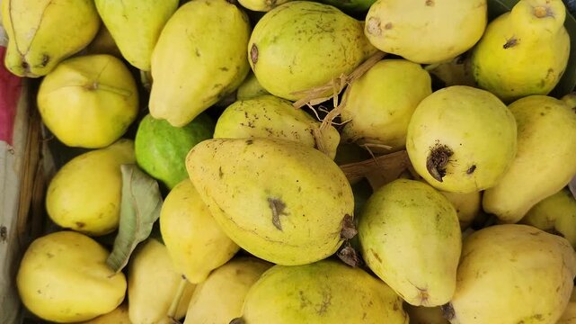Top view of fresh ripe yellow guavas in a pile
