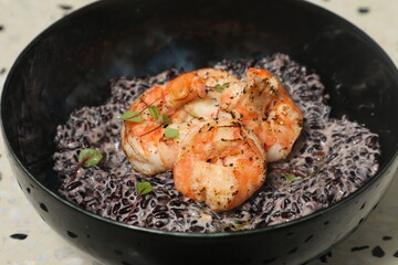 Fototapeta premium Crevettes servies sur riz noir en cuisine