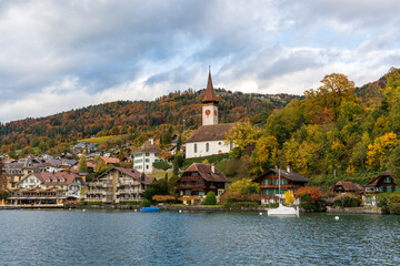 Kirche Hilterfingen church building situated on a green hill with autumn trees by Lake Thun. Hilterfingen, Canton of Bern, Switzerland.