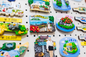 Fototapeta premium Tourist gifts and Korean souvenirs from Jeju Island, Jeju-do, South Korea, tangerine hallabong figures in orange color, knitted toys, fridge magnets, key ring keychain, a local gift vendor shop market
