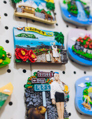 Fototapeta premium Tourist gifts and Korean souvenirs from Jeju Island, Jeju-do, South Korea, tangerine hallabong figures in orange color, knitted toys, fridge magnets, key ring keychain, a local gift vendor shop market