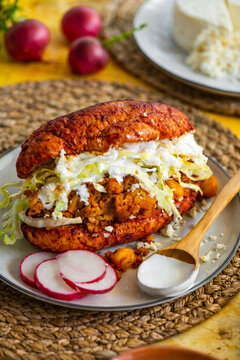 Pambazo mexicano con papa y chorizo, lechuga, crema y queso fresco