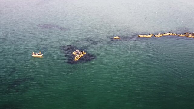 Small fishing boat by islands in ocean 